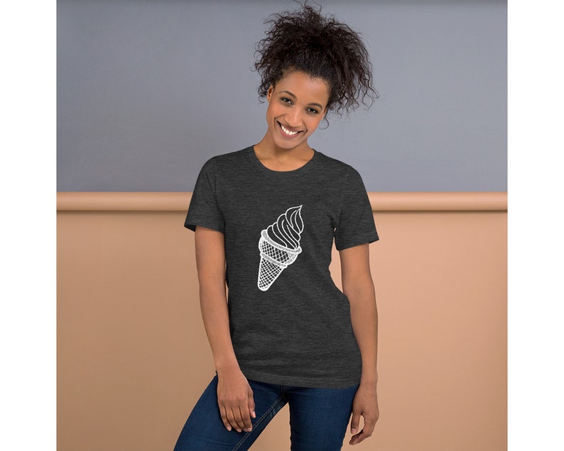 Puede incluir: Una camiseta gris oscuro jaspeada con un contorno blanco de un cono de helado.