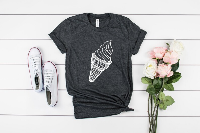 Puede incluir: Una camiseta gris oscuro con un gr&aacute;fico blanco de un cono de helado.