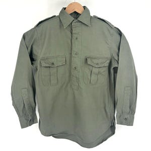 Peut inclure: Une chemise utilitaire à manches longues de couleur olive avec un col boutonné, deux poches poitrine et un devant boutonné.