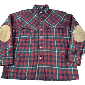 May include: A red, blue and white plaid flannel shirt with leather elbow patches. The shirt has a button-up front and two chest pockets.