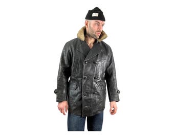 May include: A black leather peacoat with a brown faux fur collar and double breasted closure. The coat has a relaxed fit and is lined with a black fabric.