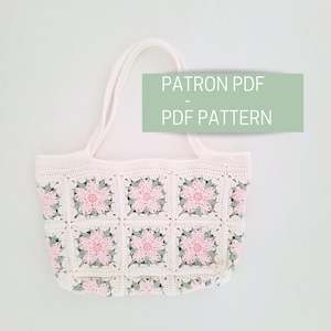 K&ouml;nnte beinhalten: Wei&szlig;e H&auml;kel-Tragetasche mit rosa und gr&uuml;nen Blumenquadraten. Die Tasche hat zwei Henkel und tr&auml;gt den Schriftzug "PATRON PDF - PDF PATTERN" auf einem gr&uuml;nen Rechteck.