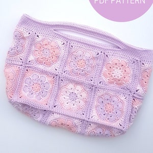 May include: A crocheted tote bag with a pink and purple color scheme. The bag is made of squares with a flower design in the center. The text "PATRON PDF - PDF PATTERN" is visible in the top right corner of the image.