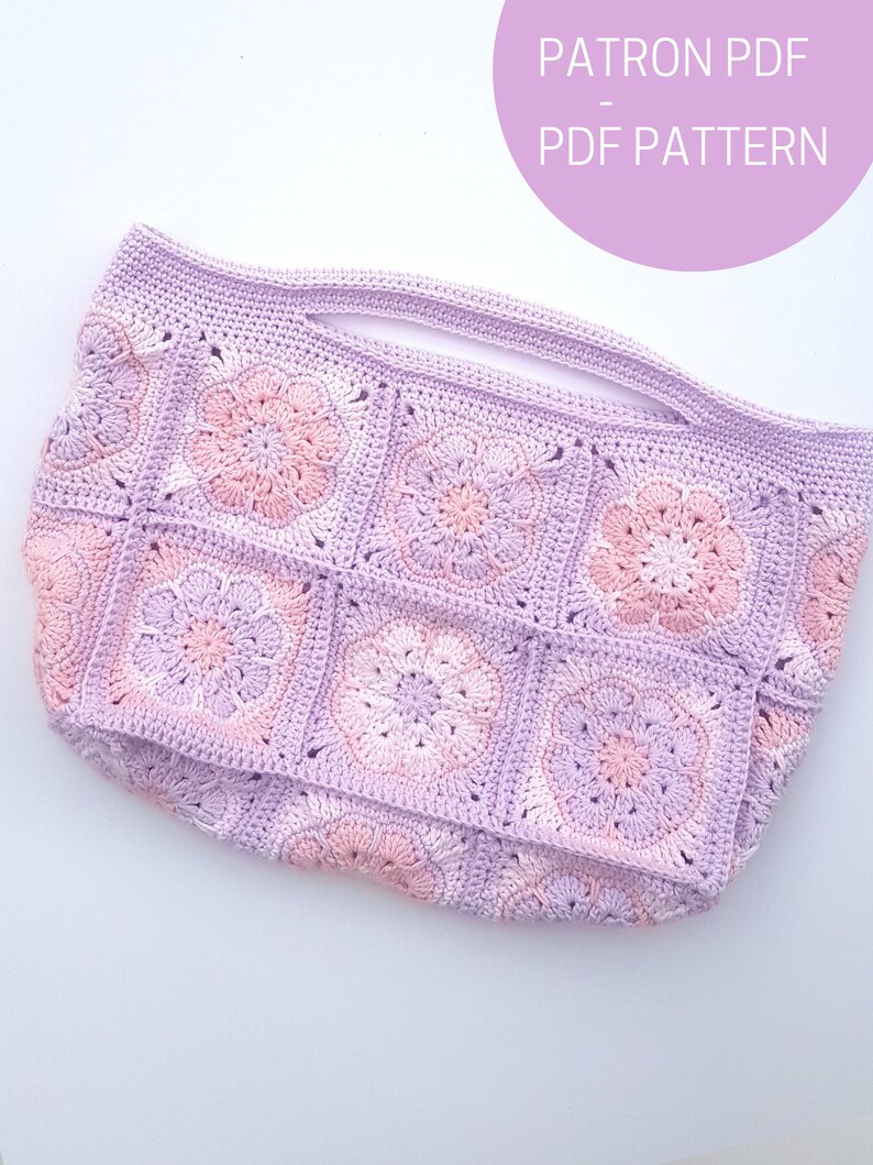 May include: A crocheted tote bag with a pink and purple color scheme. The bag is made of squares with a flower design in the center. The text "PATRON PDF - PDF PATTERN" is visible in the top right corner of the image.