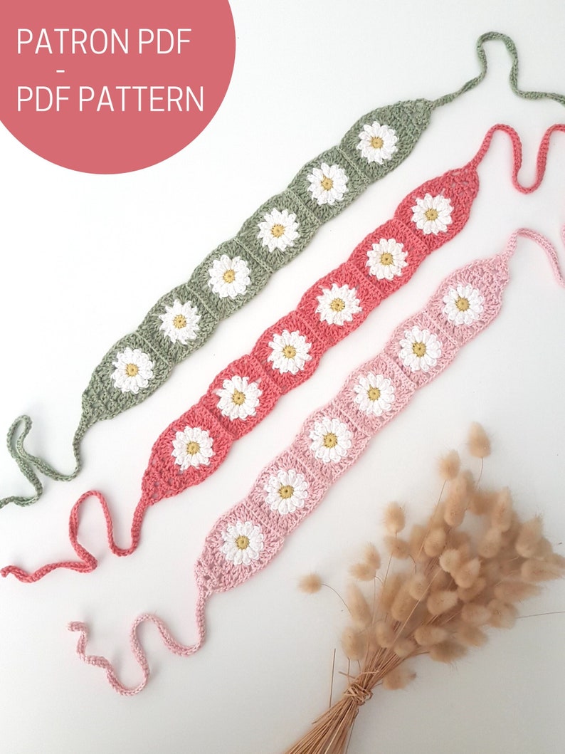 May include: Three crocheted headbands with daisy flower designs in green, pink, and coral colors. The headbands have long ties on each end.  PATRON PDF - PDF PATTERN.