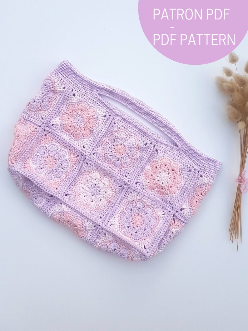 May include: A crochet tote bag with a light purple and pink color scheme. The bag is made of granny squares with a floral design. The text "PATRON PDF PDF PATTERN" is visible in the top right corner of the image.