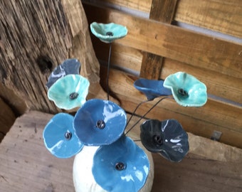 9 small ceramic flowers in shades of blue and celadon on wire