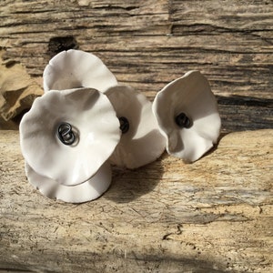 5 small rounded white ceramic flowers on wire