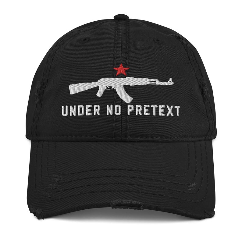 May include: Black distressed baseball cap with a white embroidered image of an AK-47 rifle with a red star and the text "UNDER NO PRETEXT".