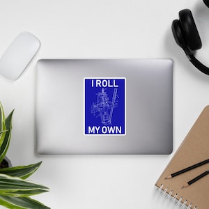 May include: A blue sticker with a white outline of a rolling machine and the text "I roll my own".