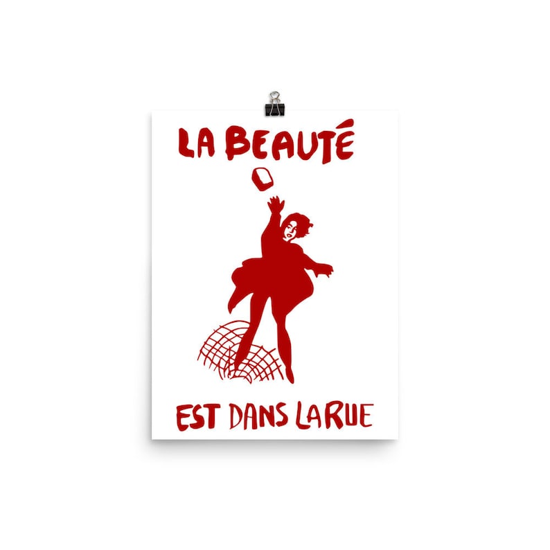 May include: A red silhouette of a person throwing a brick with the text "LA BEAUT&Eacute; EST DANS LA RUE" in red.