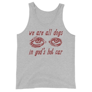 May include: A grey tank top with the text "we are all dogs in god's hot car" in red lettering. The text is accompanied by a drawing of two eyes.