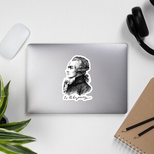 May include: Black and white line drawing of a man with a powdered wig and a signature that reads "de Robespierre".