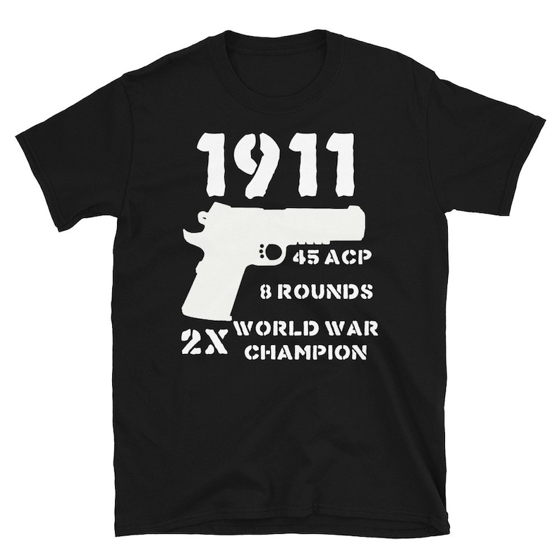 May include: Black t-shirt with white text and a silhouette of a pistol. The text reads "1911", "45 ACP", "8 Rounds", "2X World War Champion".