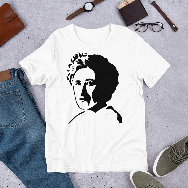 May include: A white t-shirt with a black and white silhouette of a woman with curly hair.