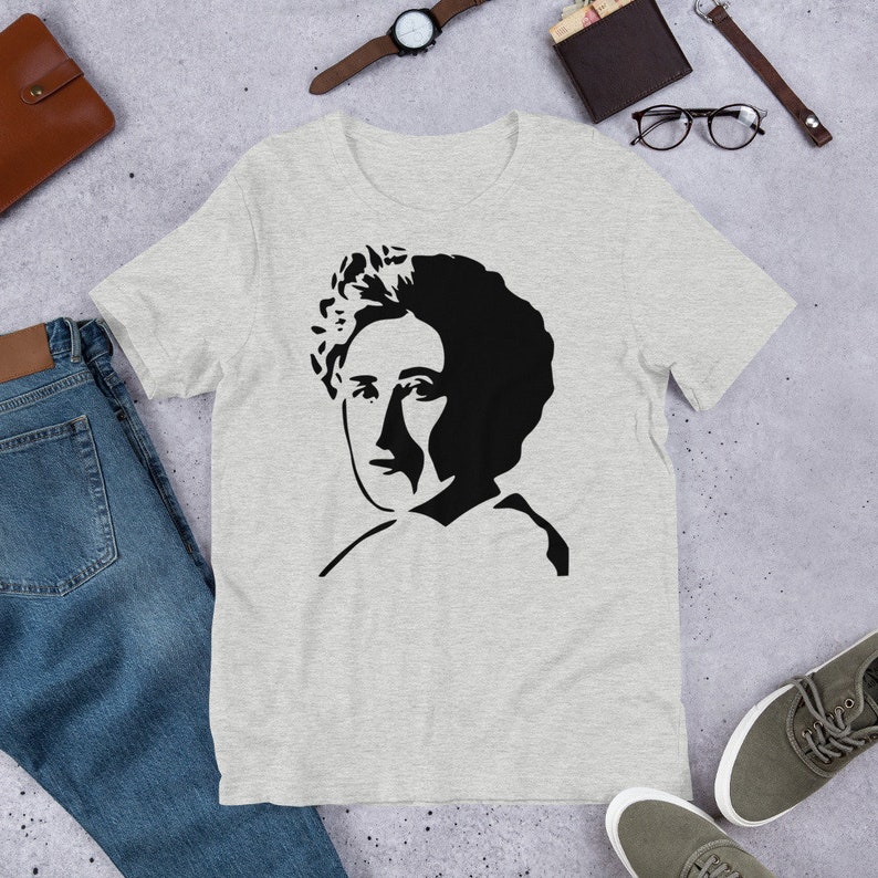 May include: A heather grey t-shirt with a black and white silhouette of a woman with curly hair.