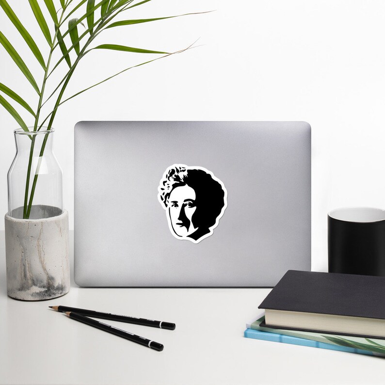 May include: Black and white silhouette sticker of a person with curly hair. The sticker is on a silver laptop.