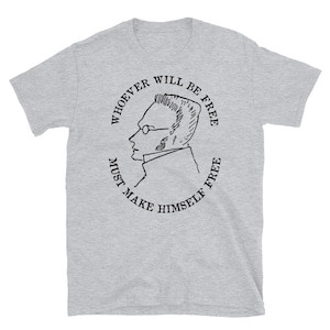 May include: Gray t-shirt with a black and white illustration of a man's profile in a circle. The text around the circle reads "Whoever will be free must make himself free."