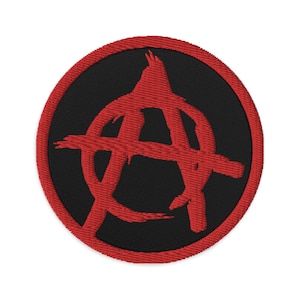 Può includere: Toppa ricamata di colore rosso con un simbolo anarchico su sfondo nero con bordo rosso.