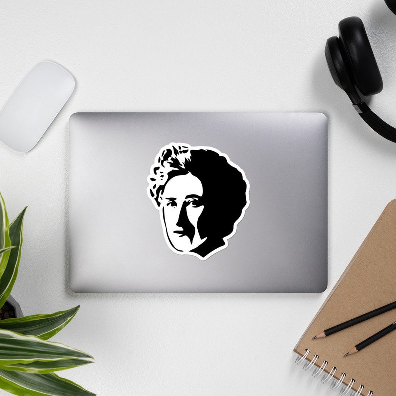 May include: Black and white silhouette of a woman's face with curly hair. The image is a simple, stylized portrait.