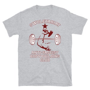 May include: Grey t-shirt with a red graphic of a bicep lifting a barbell. The graphic includes a red star and the text "SWOLETERIAT ANTI-FASCIST BODYBUILDING CLUB".