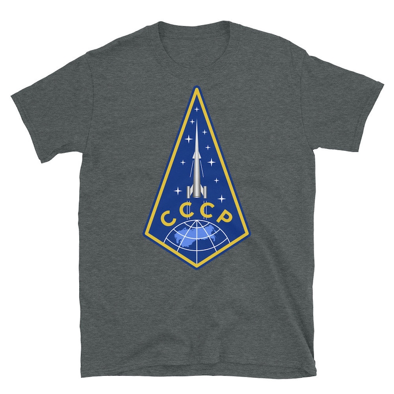 May include: A dark heather grey t-shirt with a graphic of a rocket launching from a globe with the text "CCCP" in yellow letters.