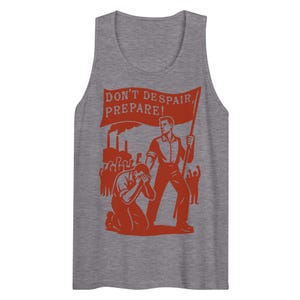 Op de afbeelding: Grijze tanktop met een rode afbeelding. De afbeelding toont een man die een spandoek vasthoudt met de tekst "DON'T DESPAIR, PREPARE!" met een knielende figuur en fabriekssilhouetten. Vintage-geïnspireerd ontwerp.