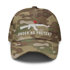 May include: A camouflage baseball cap with a white embroidered AK-47 rifle and the text "UNDER NO PRETEXT" in white. A red star is embroidered above the rifle.