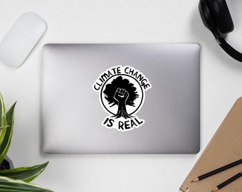 May include: Black and white sticker with a fist emerging from a tree, surrounded by a circle with the text "Climate Change is Real".