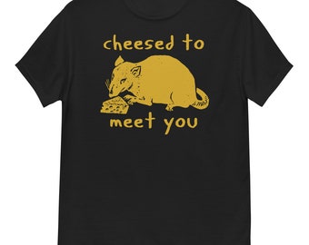 Op de afbeelding: Zwart T-shirt met een gele afbeelding van een rat die een plakje kaas eet. De tekst "cheesed to meet you" is in geel onder de rat gedrukt.