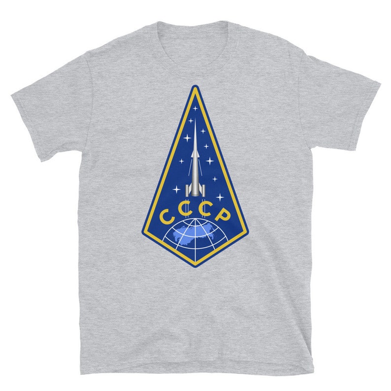 May include: A gray t-shirt with a blue and yellow patch featuring a rocket launching from a globe with the text "CCCP" in yellow.