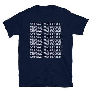 Peut inclure: T-shirt bleu marine avec la phrase "DEFUND THE POLICE" r&eacute;p&eacute;t&eacute;e 11 fois en texte blanc.
