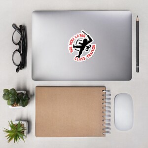 May include: A white sticker with a black silhouette of a person holding a weapon. The text around the person reads "See You Later Class Traitor".