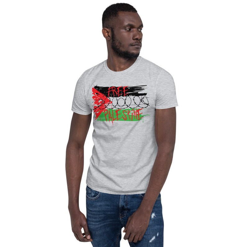 May include: A gray t-shirt with a black and white graphic of a Palestinian flag with barbed wire and the words "Free Palestine".