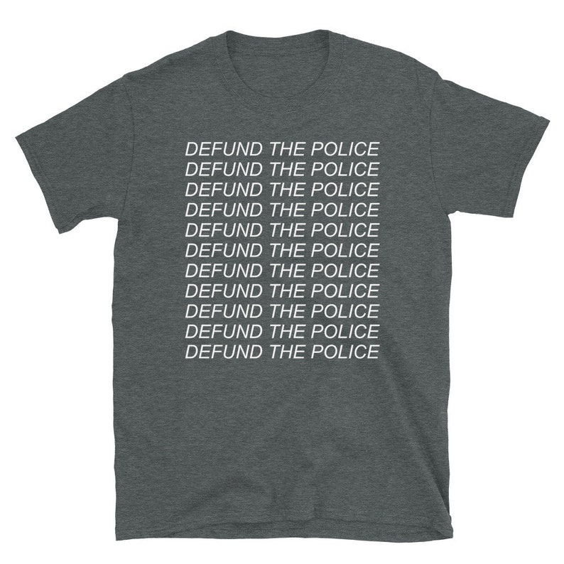 Peut inclure: Un t-shirt gris fonc&eacute; chin&eacute; avec la phrase "DEFUND THE POLICE" r&eacute;p&eacute;t&eacute;e 11 fois en texte blanc.