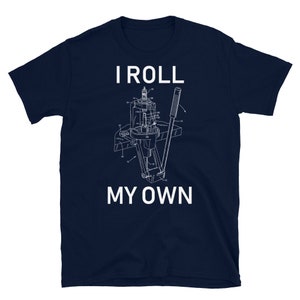 Può includere: Una t-shirt blu navy con una grafica bianca di un dispositivo meccanico e il testo "I roll my own".