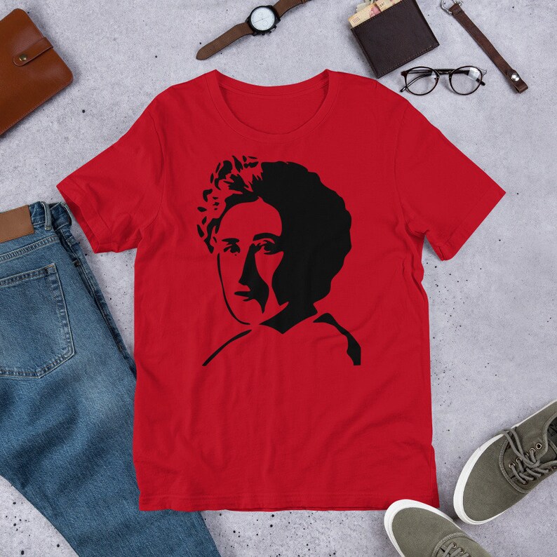 May include: Red short-sleeved t-shirt with a black silhouette of a woman's face.