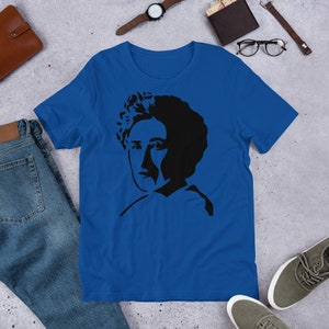 May include: A royal blue t-shirt with a black silhouette of a woman with curly hair.