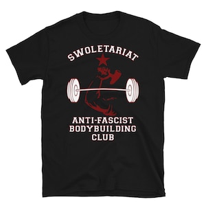 May include: Black t-shirt with red and white text that reads "Swole-tariat Anti-Fascist Bodybuilding Club". A red silhouette of a bicep lifting a barbell is in the centre of the shirt.