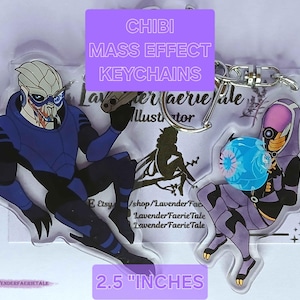 May include: Chibi Mass Effect keychains featuring two characters in blue and purple. The keychains are 2.5 inches in size and have a silver keyring. The text "CHIBI MASS EFFECT KEYCHAINS" is visible.