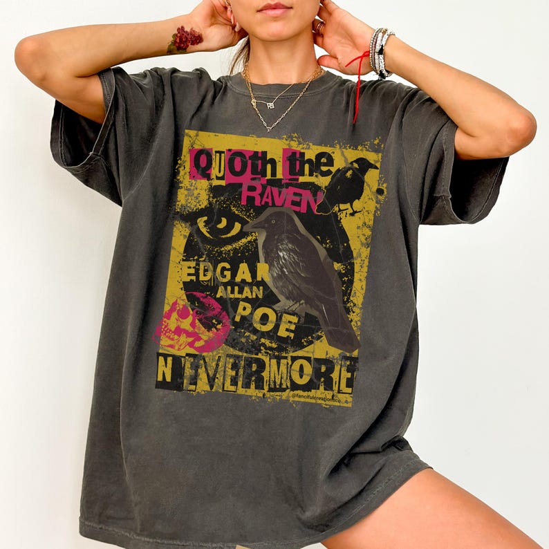 May include: Dark grey t-shirt with a graphic design inspired by Edgar Allan Poe's poem "The Raven." The design includes a raven illustration, the words "Quoth the Raven," "Edgar Allan Poe," and "Nevermore."