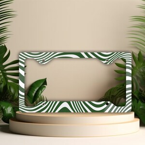 May include: Green and white striped license plate frame with a wavy pattern.