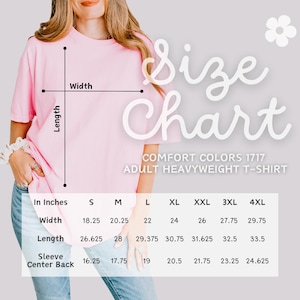 May include: Size chart for adult heavyweight t-shirts in Comfort Colors 1717. The chart shows measurements in inches for width, length, and sleeve center back for sizes S, M, L, XL, XXL, 3XL, and 4XL.