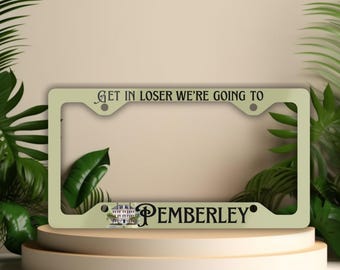 以下が含まれることがあります： 「Get in loser we're going to Pemberley」というテキストと小さな家の画像が描かれた、薄い緑色の金属製のナンバープレートフレームです。