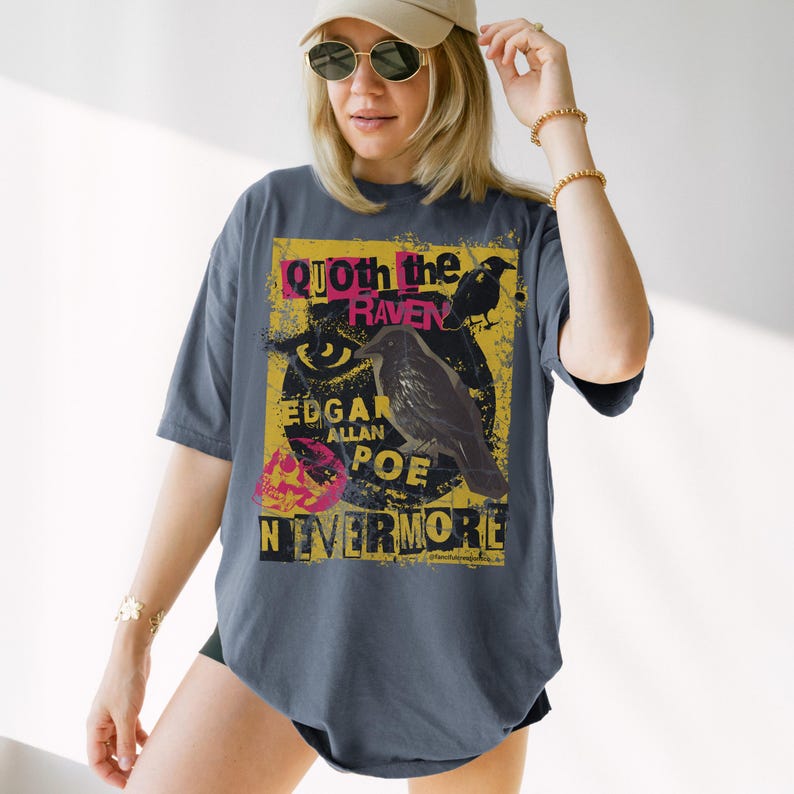 May include: Dark grey t-shirt with a graphic design inspired by Edgar Allan Poe's poem, "The Raven." The design includes a raven illustration, the text "Quoth the Raven," "Edgar Allan Poe," and "Nevermore" in a distressed style.