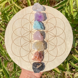 Könnte beinhalten: Ein Chakra-Gitter aus Holz mit sieben Kristallen in einem Regenbogenmuster. Die Kristalle sind klarer Quarz, Amethyst, Aquamarin, Rosenquarz, Citrin, Karneol und schwarzer Obsidian.