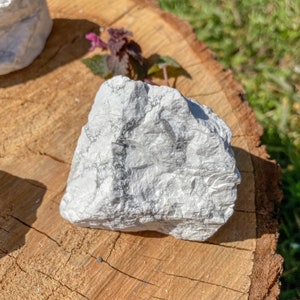 K&ouml;nnte beinhalten: Ein wei&szlig;er, grob strukturierter Stein mit einer nat&uuml;rlichen, unregelm&auml;&szlig;igen Form. Der Stein hat eine wei&szlig;e, marmorierte Optik mit grauen Adern.