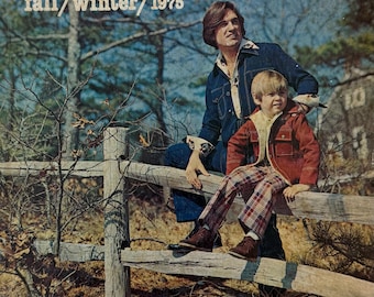 May include: A vintage Sears fall/winter 1975 catalogue cover featuring a person in a dark blue denim jacket and jeans sitting on a wooden fence with a child in a rust-coloured jacket and plaid trousers. The text reads Sears fall/winter 1975.