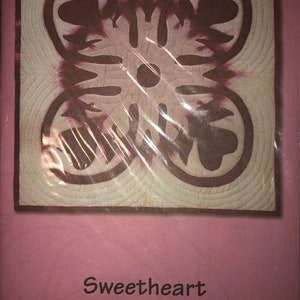 May include: A pink and brown quilt pattern called "Sweetheart Ku'uipo" with a finished size of 18 inches by 18 inches.