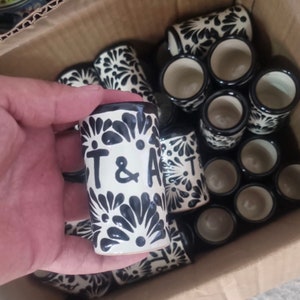 Peut inclure: Un ensemble de verres à shot en céramique noir et blanc avec un motif floral. Les verres sont personnalisés avec les initiales "T & A".
